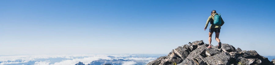 Person facing view from top of summit