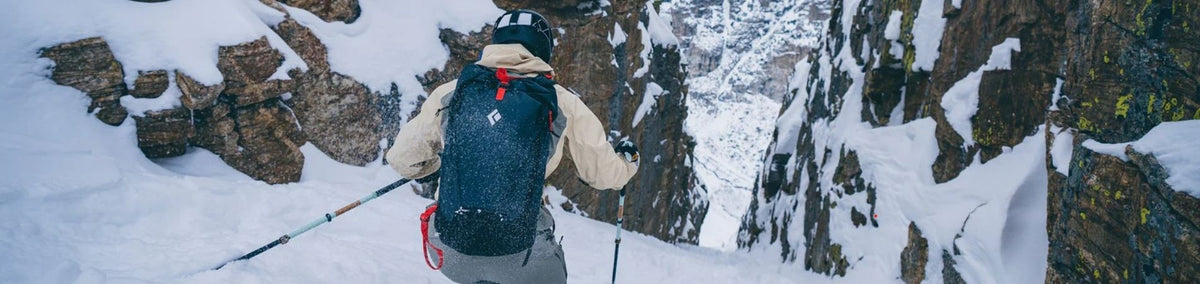 Person skiing down mountain through small canyon