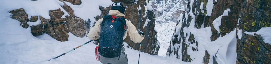Person skiing down mountain through small canyon