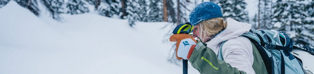 Woman in snow wearing bright orange snow gloves